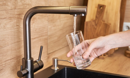 woman getting water from a sink